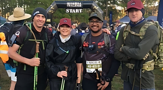 A group of 4 people smiling at the start line of the Kokoda Challenge. 