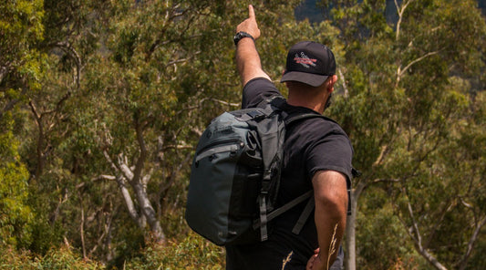 A man pointing towards the bush wearing a North Storm® 30L Backpack. 