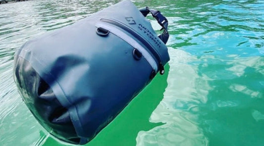 A NORTH STORM 20 LITRE DRY BAG FLOATING ON TOP OF THE WATER.