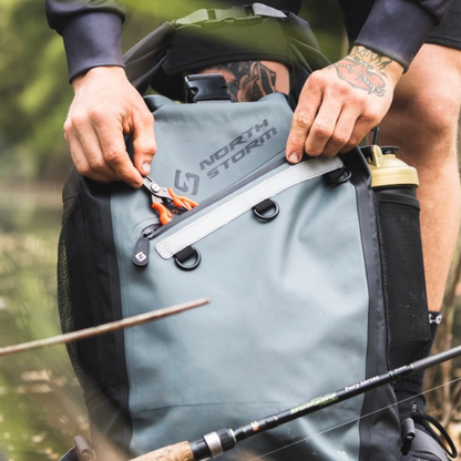 A man taking out a pair of snips from the front pocket of his 30L Waterproof Backpack Waterproof Bag from North Storm®